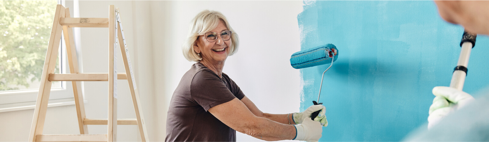 mature woman painting a wall